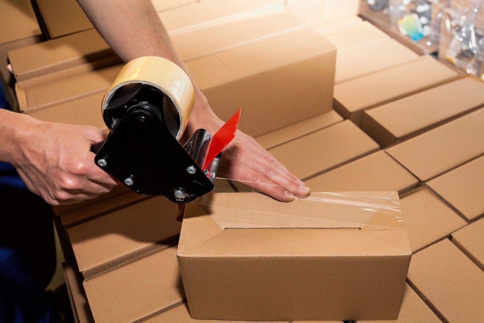 A person is cutting cardboard boxes with scissors.